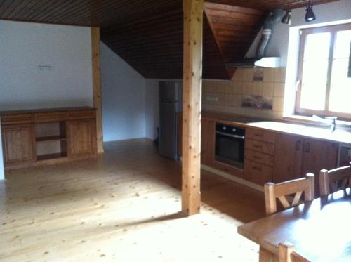 a kitchen with wooden cabinets and a sink and a table at Penzion Terezka in Králíky