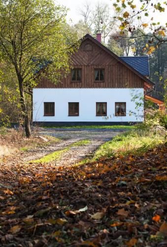 a large white building next to a barn at Penzion Terezka in Králíky