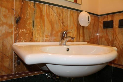 a white sink in a bathroom with wooden walls at Hotel Paradiso Delle Madonie in Castelbuono