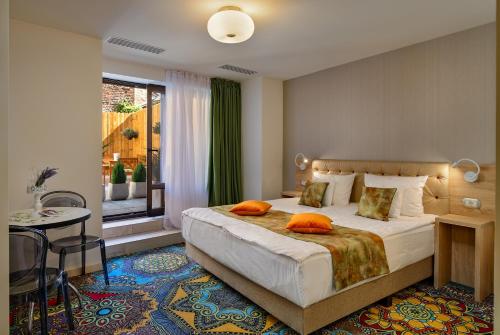 1 dormitorio con 1 cama con almohadas de color naranja en Blumenhaus Sibiu, en Sibiu