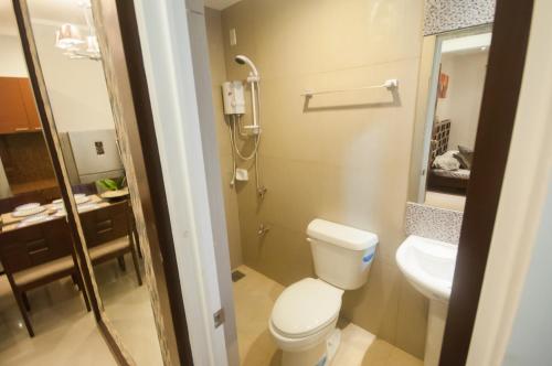 een kleine badkamer met een toilet en een wastafel bij NF Suites in Davao City
