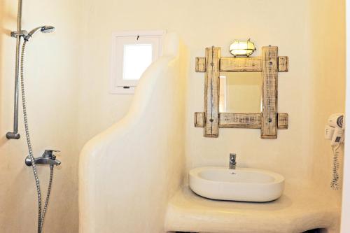 uma casa de banho com um lavatório e um espelho em Sarakiniko View Studios em Mandrakia