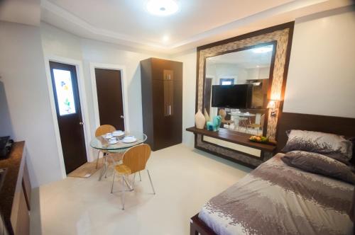 una camera con letto, tavolo e specchio di NF Suites a Davao