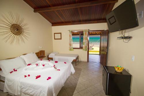 a bedroom with a bed with red flowers on it at Pousada Portal do Maragogi in Maragogi