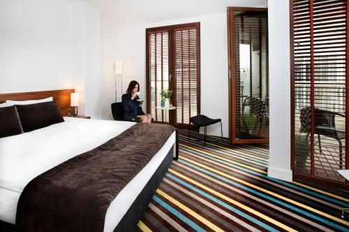 a woman sitting in a chair in a hotel room at Bayjonn Boutique Hotel in Sopot