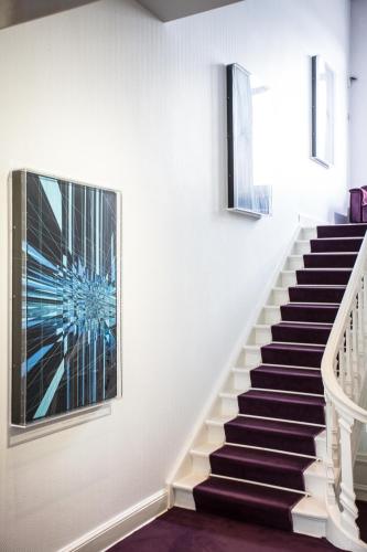 a staircase in a house with a painting on the wall at L'Esplanade Lille in Lille