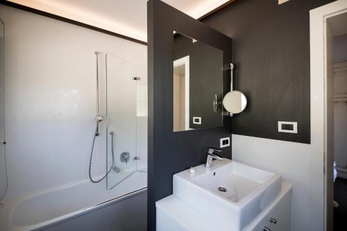 a bathroom with a shower, sink, and mirror at Chalet Hotel Hartmann - Adults Only in Ortisei