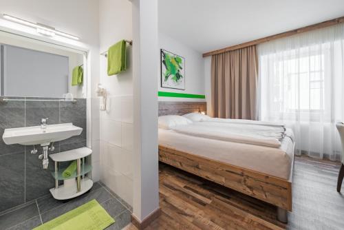 Habitación de hotel con cama y lavabo en City Rooms Wels - contactless check-in en Wels