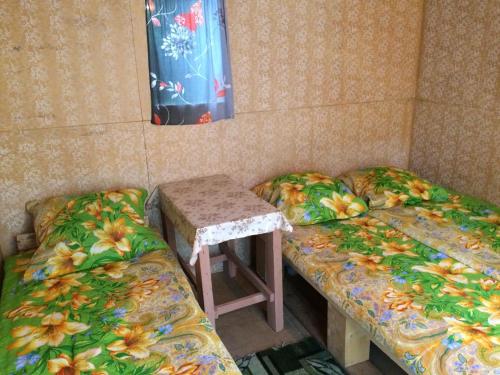 a room with two beds and a table in it at Turbaza Kedroviy bereg in Artybash