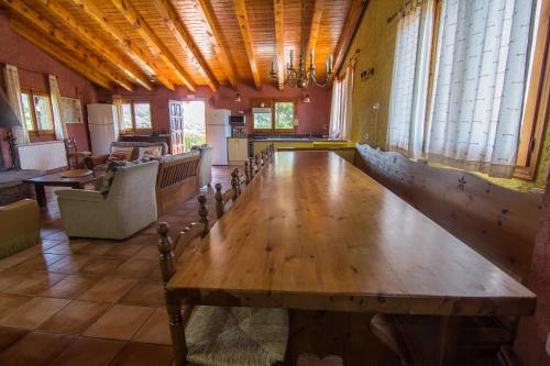 una gran mesa de madera en una habitación con ventanas en Casa Sisquet, en Montcortès