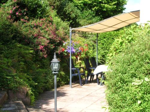 a patio with an umbrella and a table and chairs at Gite Le Paradis in Saint-Nabord