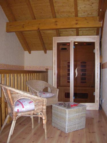 a room with wicker chairs and a porch at Gite Le Paradis in Saint-Nabord