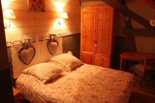 Saint-NabordにあるGite Le Paradisのベッドルーム1室(ベッド1台、壁にハート2つ付)