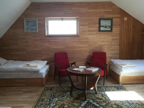 Cette chambre comprend deux lits, une table et des chaises. dans l'établissement Apartman v zahrade, à Nová Včelnice