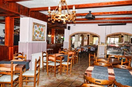 um restaurante com mesas e cadeiras de madeira e um bar em Hostal Isabel em Blanes