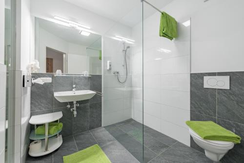 a bathroom with a toilet and a sink and a shower at Hotel "City Rooms Wels" in Wels