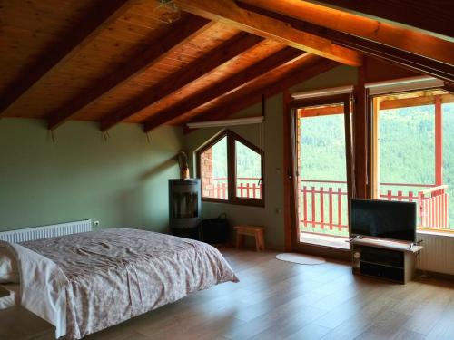 a bedroom with a bed and a flat screen tv at Oresivio in Metsovo
