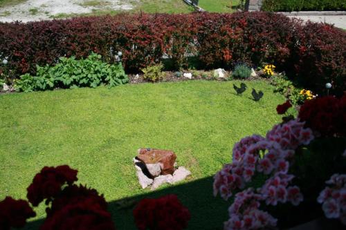 a garden with flowers and a rock in the grass at Haus Angerbichl in Ramsau