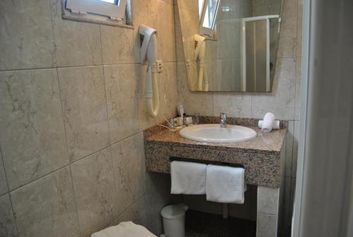 a bathroom with a sink and a mirror at Hotel Peninsular- Porto in Porto