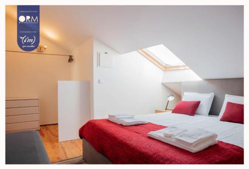 um quarto com uma grande cama branca com almofadas vermelhas em ORM - Cristal Apartment no Porto