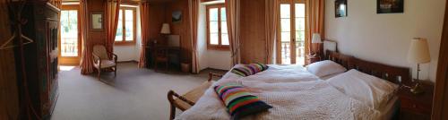 ein Schlafzimmer mit einem Bett in einem Zimmer mit Fenstern in der Unterkunft Hotel de la Sage in La Sage