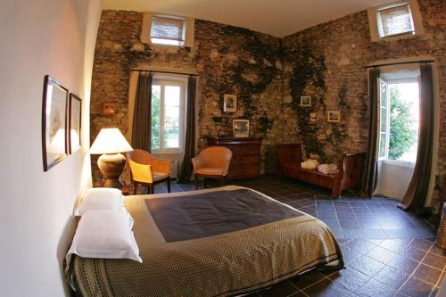 1 dormitorio con 1 cama en una habitación con paredes de ladrillo en Le Prieuré des Sources, en La Répara