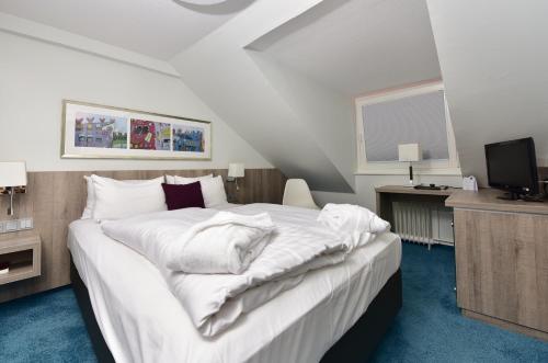 Säng eller sängar i ett rum på Frühlings-Hotel