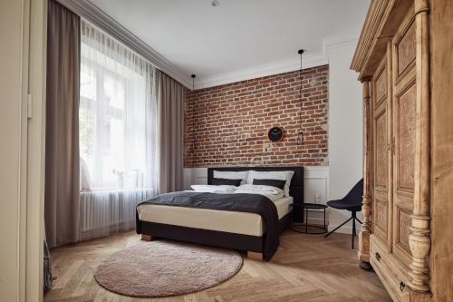una camera da letto con un muro di mattoni e un letto di St Agnes Apartments Old Town a Cracovia