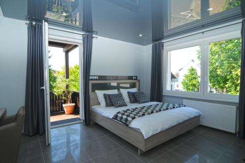 ein Schlafzimmer mit einem Bett und zwei Fenstern in der Unterkunft Nanis Hotel & Appartements in Steinhude