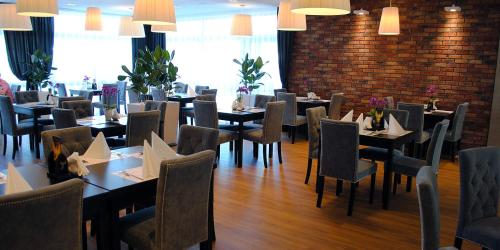 un restaurante con mesas y sillas y una pared de ladrillo en Portius, en Krosno
