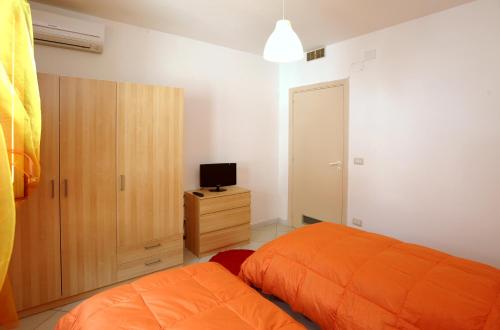 アトラーニにあるAmalfi Coast Housesのベッドルーム(オレンジ色のベッド1台、テレビ付)