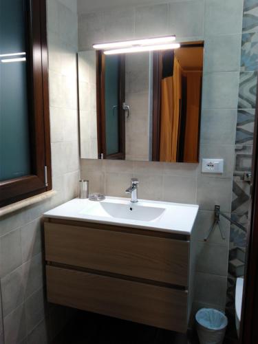 a bathroom with a sink and a mirror at La Maiolica B&B in Balestrate