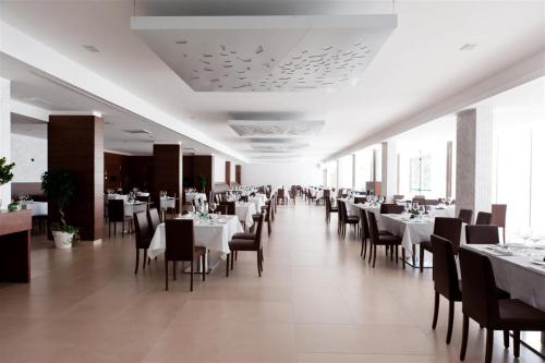 a dining room with white tables and chairs at Vea Resort Hotel in Mercato San Severino