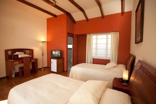 a hotel room with two beds and a window at Hotel Villa Antigua in Sucre