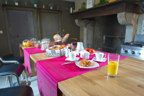 una mesa con un mantel rosa con comida y bebida en Château de Baylac, en Bugnein