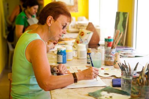 a woman sitting at a table working on a piece of paper at El Mouradi Djerba Menzel in Midoun