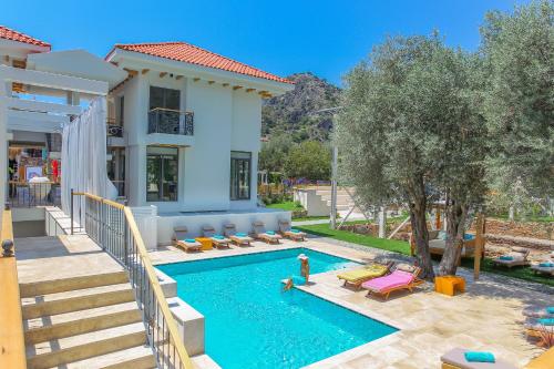 a villa with a swimming pool and a house at Ecclesia Hotel - Adult Only (+14) in Oludeniz