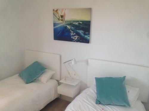 a bedroom with two beds and a picture on the wall at BURUMENDI 4 in Mutriku