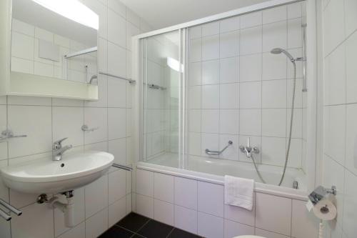 ヴェンゲンにあるChalet Goldenhornの白いバスルーム(シンク、シャワー付)