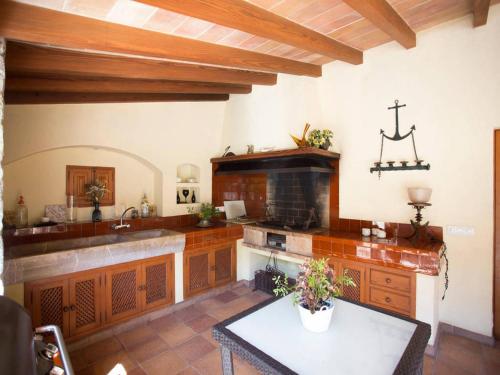 a large kitchen with wooden cabinets and a table at AGUAIT - Villa approximately aprox 4O OOO meters PLUS PRIVATE mountain approx 3 minutes walking from the beach Ideal for relaxation sport in Port de Pollensa