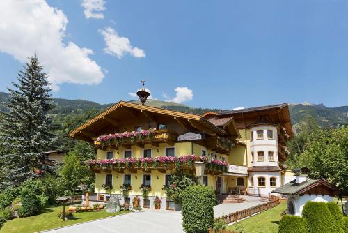 a large house with flowers on the side of it at Landhotel Untermüllnergut in Dorfgastein