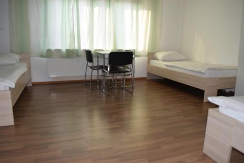 a room with two beds and a table and chairs at Stuttgart Wohnung Ost in Stuttgart