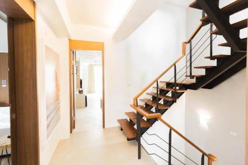 a staircase in a house with white walls and wooden railings at sunlight mound in Yuanshan