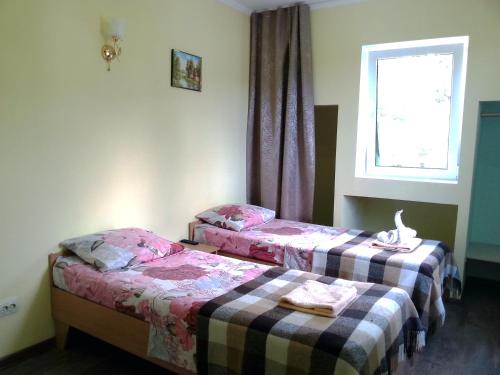 two beds in a room with a window at Guest House at Kirova Street in Yalta