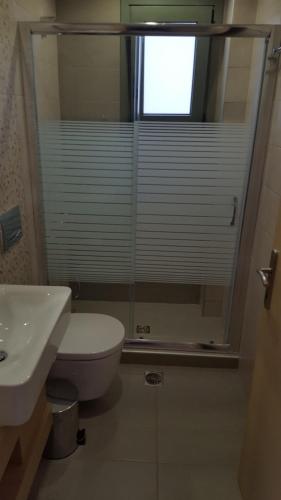 a bathroom with a toilet and a sink and a window at Ionian Green Villas in Preveza