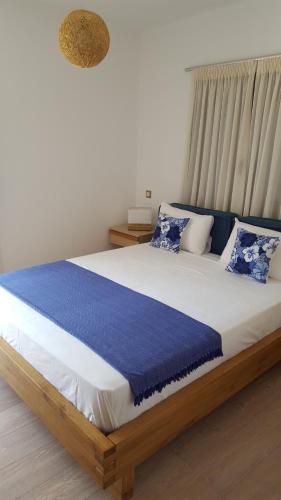 a bedroom with a large bed with blue and white pillows at Ionian Green Villas in Preveza