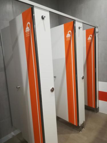 a row of lockers with orange and white doors at Albergue Milladoiro in Milladoiro
