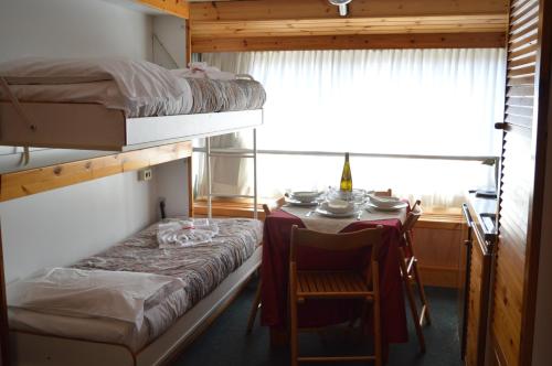 a room with a table and a bed and a table and chair at Residence Il Vigo di Marilleva in Marilleva