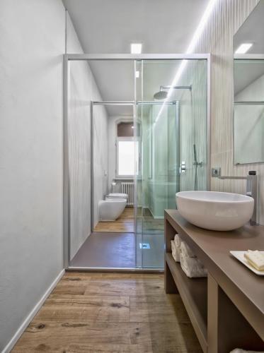 a bathroom with two sinks and a glass shower at Suite Vogue Epoca in Voghera