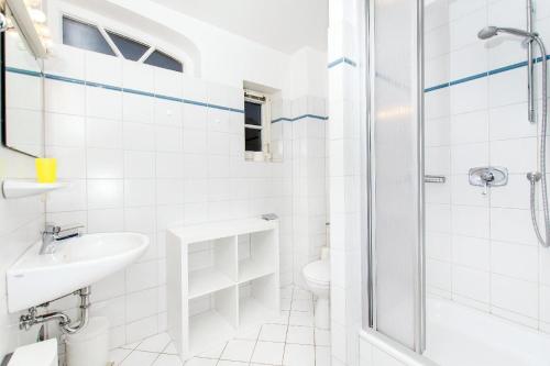 a white bathroom with a shower and a sink at Westhof-3 in List